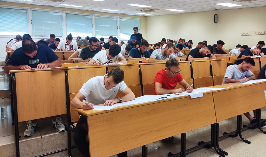 
			      Aspirantes a docentes se examinan en un aula.			    
			  